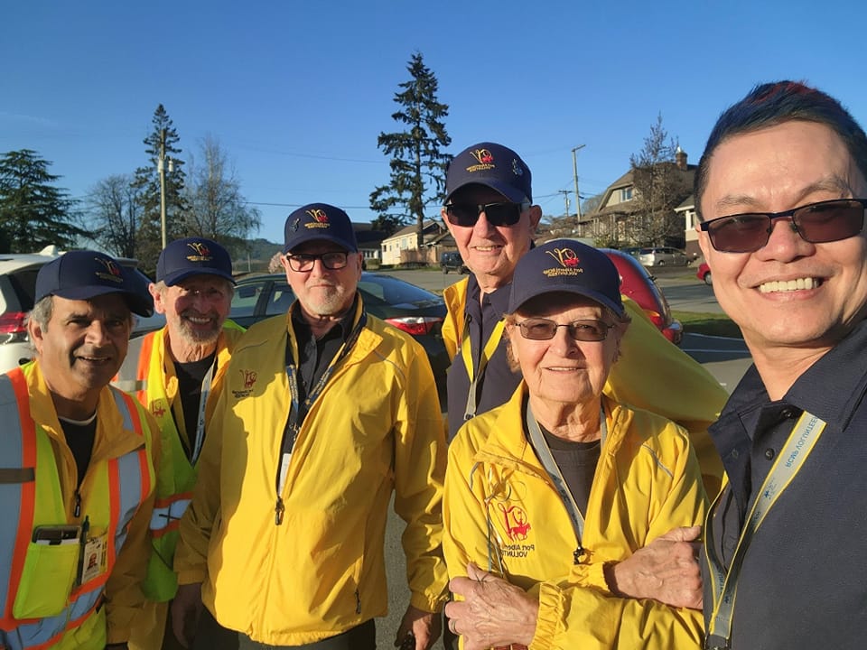 Community policing volunteers in yellow jackets and hats
