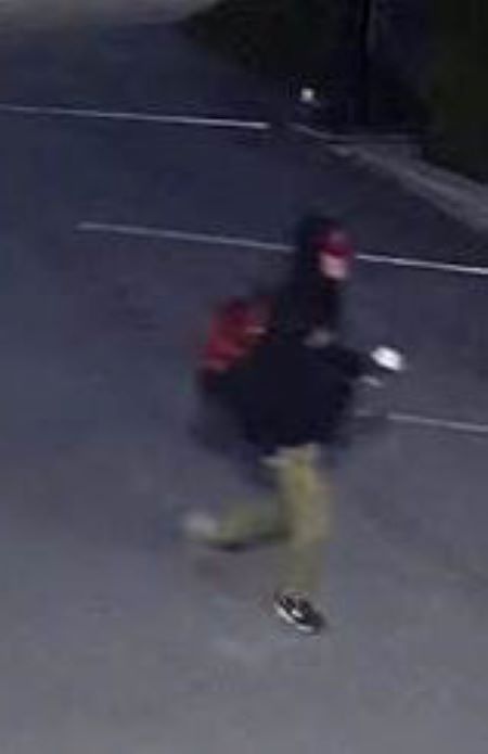 Image du suspect marchant dans un stationnement avant l’incendie.