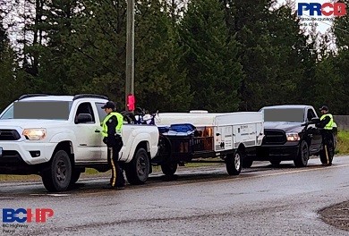 A police vehicle with lights flashing with a stopped vehicle 