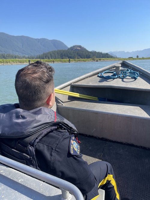 Coquitlam RCMP officer faces the front of the police boat as it travels through Pitt River