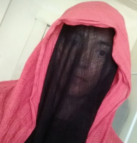 Photo of Kari Anne Stiele-Jules with a pink cloth covering her head and shoulders and black coloured veil over her face