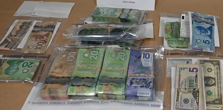 Plusieurs sacs de preuves avec des piles de devises canadiennes et américaines.