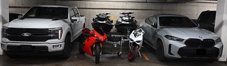 Une camionnette haut de gamme stationnée à côté de deux motocyclettes Ducati, de deux motomarines et d’une berline haut de gamme dans un garage souterrain.