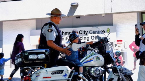 Un policier de la GRC de Richmond se tenant à côté d'un enfant sur une moto.