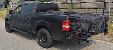 Black Ford F150 with load of lumber