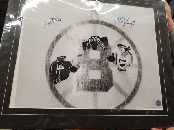 une reproduction encadrée de Jean Béliveau et Phil Esposito au centre de la patinoire de l’aréna des Bruins de Boston. 