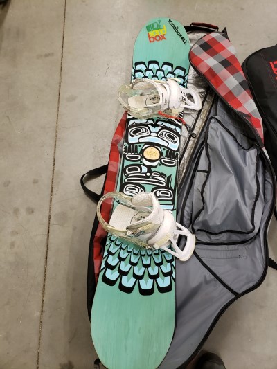 •	Snowboard three is a green Tribal snowboard with white bindings and a red, plaid bag