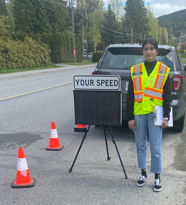 Volunteer standing with Speed Watch Sign