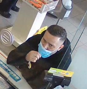 Photo of male suspect # 1 wearing black jacket, blue and white medical mask with short dark hair