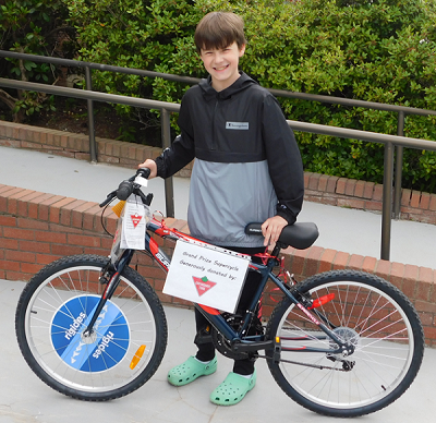 Raffle winner, boy standing with new bike donated by Canadian Tire
