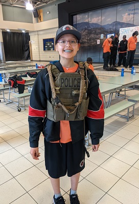Photo d’un jeune portant un gilet de policier.