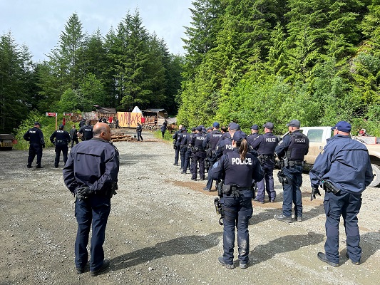 Photo des policiers se regroupant à l’extérieur du camp des manifestants sur le chemin forestier 