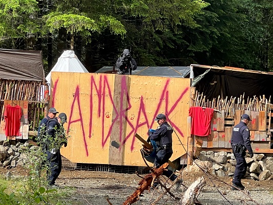 Photo des policiers à l’entrée du camp des manifestants sur le chemin forestier