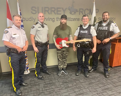 Photo of recovered guitar and Surrey RCMP officers