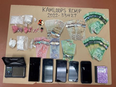 Seven stacks of Canadian currency, prepackaged suspected drugs, five cell phones, a notebook and a scale.